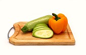 Zucchini and ripe yellow bell pepper on a cutting board on a light background. Natural product. Natural color. Close-up.
