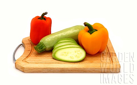 Zucchini_and_ripe_sweet_pepper_of_different_colors_on_a_cutting_board_on_a_light_background_Natural_