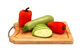Zucchini and ripe sweet pepper of different colors on a cutting board on a light background. Natural product. Natural color. Close-up.