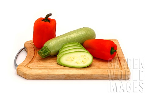 Zucchini_and_ripe_sweet_pepper_of_different_colors_on_a_cutting_board_on_a_light_background_Natural_