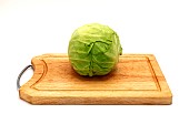 Head of cabbage on a wooden cutting board on a light background. Natural product. Natural color. Close-up.