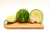 Sliced head of cabbage on a cutting board on a light background. Natural product. Natural color. Close-up.