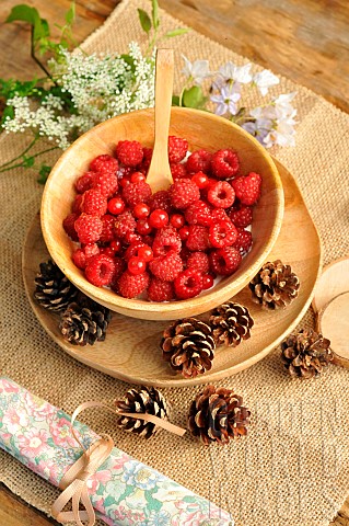 Soft_fruit_dessert_Raspberries_and_red_currants_from_the_garden_in_a_wooden_bowl_country_atmosphere_