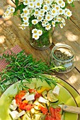 Rosemary (Rosmarinus officinalis) in cooking. Fresh and dried rosemary in a glass jar, medicinal and aromatic plant used in cooking, plate with vegetables and natural tofu