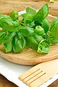 Basil (Ocimum basilicum), Basil in the kitchen, a wooden dish and utensil, fresh basil leaves