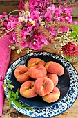 Flat peaches (Prunus persica var. platycarpa), Sweet pea (Lathyrus odoratus) and white asters, Chamomile and Valerian flowers from the garden. Summer fruits