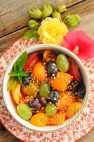 Summer_fruit_salad_with_melon_grapes_plums_peaches_mint_buckwheat_seeds_hazelnuts_edible_hollyhock_f