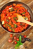 Pan-fried tomatoes (Solanum lycopersicum) from the garden, 3 varieties of Basil (Ocimum basilicum) and peppers, garlic, cooking, vegetable garden, good food from your garden