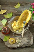 Spaghetti squash (Cucurbita pepo) and seeds, in preparation for cooking, and Tomato (Solanum lycopersicum)