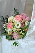 Wedding bouquet on an armchair, Rose (Rosa sp), Gypsophila (Gypsophila paniculata) and foliage, romantic atmosphere
