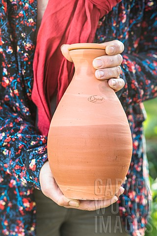 Woman_holding_an_oyas_or_watering_jar_containing_water_the_boundary_is_clearly_visible_from_the_outs