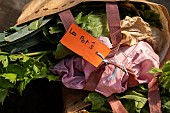 Label on a basket of vegetables with Les Pots written on it at the shared garden Les Potiront. Collective garden of the association Les Potiront shared organic market gardening near Lyon, Décines, France.