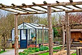 Small glass greenhouse in winter in the garden of the Arche de la Nature, Le Mans Métropole, Sarthe, France.