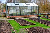 Small glass greenhouse in winter in the garden of the Arche de la Nature, Le Mans Métropole, Sarthe, France.