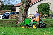 Municipal green space maintenance worker mowing a lawn, Sarthe, France