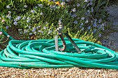 Garden hose coiled on gravel