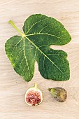 Leaf and fruit of the Grise de Saint Jean fig, on a wood background.