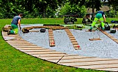 Gardeners planting a butterfly-shaped flowerbed with various succulents and flowers, Jardin des plantes, Le Mans, Sarthe, France.