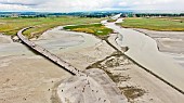 Mont Saint Michel Bay. The new access road on stilts spans the sea, replacing the old dyke road leading to the foot of Mont Saint Michel, Manche, France.