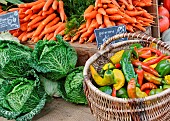 Selling vegetables at the market. Carrots, cabbages and peppers at the Jacobins market, Le Mans, Sarthe, France