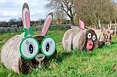 Straw-bale rabbit, pig and cow in a field at larche de la nature, Le Mans, Sarthe, France
