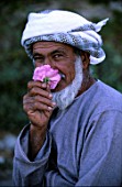 Omani smelling a Rosa Sultanate of Oman