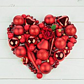 RED HEART OF BAUBLES ON WHITE WOOD