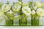 GREEN AND WHITE FLOWER ARRANGEMENT IN GREEN GLASSES