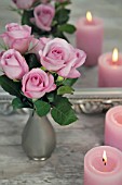 PINK ROSES AND CANDLES IN FRONT OF A MIRROR