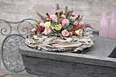 FLOWER ARRANGEMENT WITH PINK ROSES ON A WREATH OF DRIFTWOOD