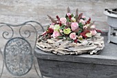 FLOWER ARRANGEMENT WITH PINK ROSES ON A WREATH OF DRIFTWOOD