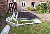 GREENHOUSE CONSTRUCTION AT WAKEFIELDS GARDEN. SITE PREPARED WITH PACKED COMPONENTS READY TO UNWRAP.