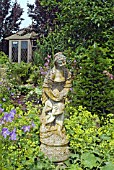 STATUE WITH CRANESBILLS AND LADYS MANTLE AT WALTERS COTTAGE