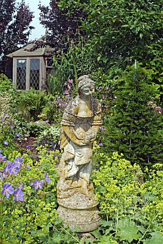 STATUE_WITH_CRANESBILLS_AND_LADYS_MANTLE_AT_WALTERS_COTTAGE