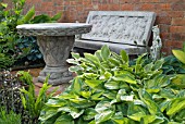 STONE SEAT AND TABLE WITH HOSTAS AT WALTERS COTTAGE