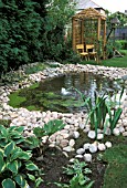 GARDEN POND WITH WHITE PEBBLE SURROUND.