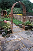 WILLOW ARCHWAY LEADING TO SMALL GARDEN