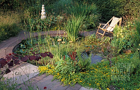 POOL_DECK_CHAIR_ON_DECKING_WATER_PLANTS_STATUE_GRASSES_BESWICK_GARDEN_CHESHIRE_CIRCULAR_POOL_BRICK_S