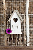 WHITE WOODEN BIRDHOUSE WITH ANEMONE SP. FLOWER