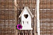 WHITE WOODEN BIRDHOUSE WITH ANEMONE SP. FLOWER