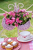 IMPATIENS IN A PINK BASKET HANGING ON A BALUSTRADE