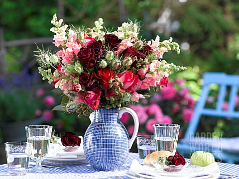 BOUQUET_OF_ROSES_IN_A_BLUE_JUG_ON_A_SET_TABLE