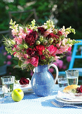 BOUQUET_OF_ROSES_IN_A_BLUE_JUG_ON_A_SET_TABLE_WITH_AN_APPLE