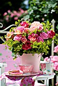 BOUQUET OF ROSES IN A PINK BUCKET ON THE BALCONY