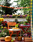 COLORFUL AUTUMNAL BALCONY WITH CONTAINER PLANTS AND FURNITURE