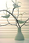 DECORATIVE TWIGS IN A VASE WITH BIRD ORNAMENTS