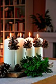 CHRISTMAS DECORATION WITH CANDLES, FIR BRANCHES AND FIR CONES