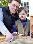 INSECT HOUSE BUILDING PROJECT WITH FATHER AND SON.  CUTTING BAMBOO INTO SMALL BUNDLES.  STEP 29