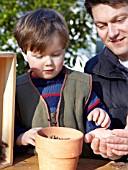 INSECT HOUSE BUILDING PROJECT WITH FATHER AND SON.  PLACING CONES IN POT.  STEP 11