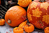 DECORATIVE PUMPKINS WITH LEAF PATTERN ON OLD TABLE WITH LANTERN AND TYPEWRITER